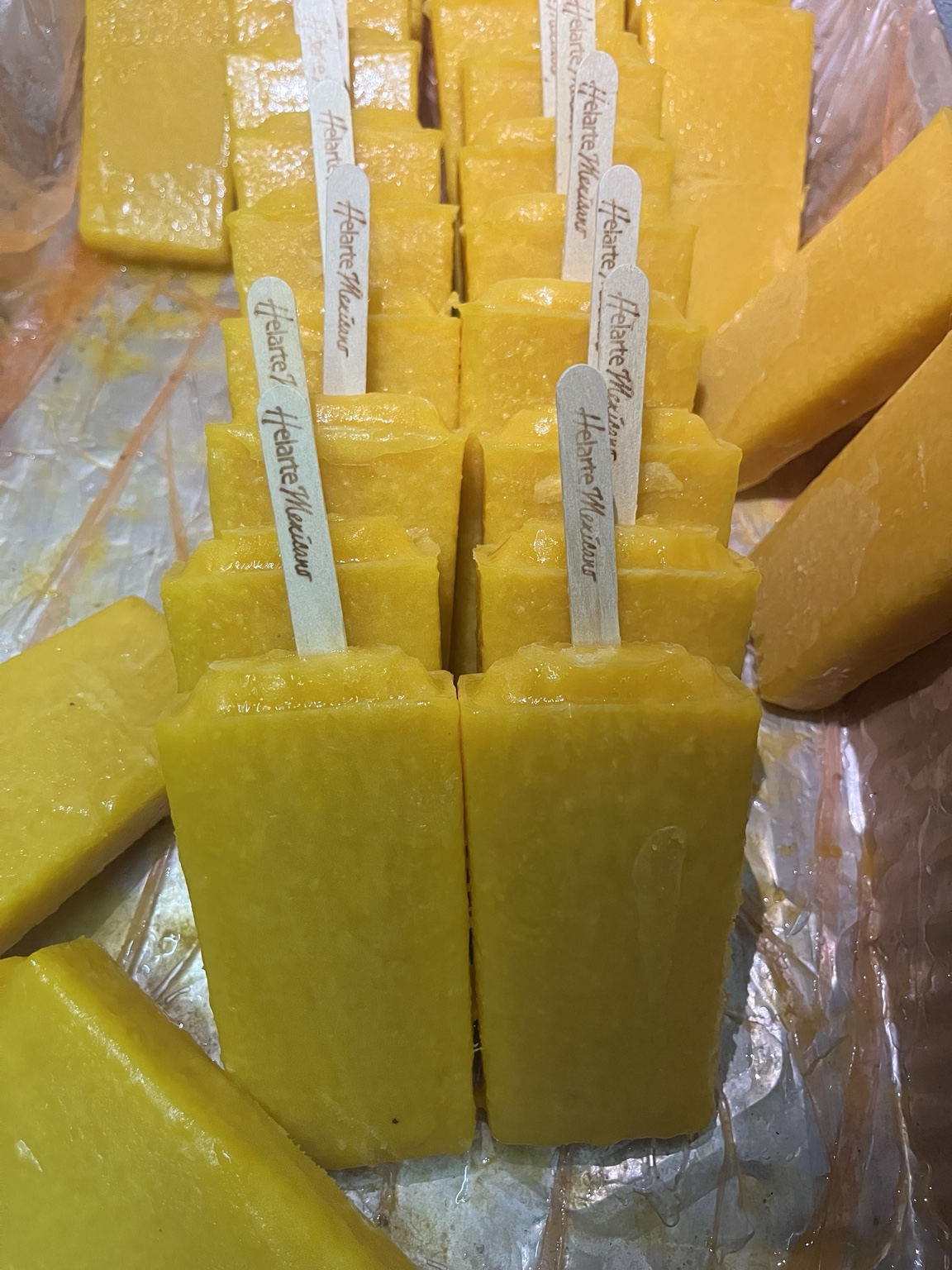 Paletas de mango de Helarte con trozos de fruta y palitos de la marca